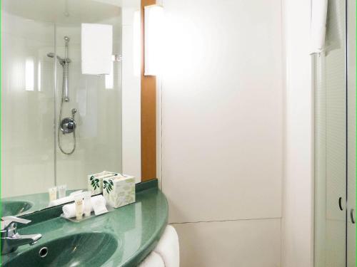 a bathroom with a green sink and a mirror at ibis Thornleigh in Thornleigh