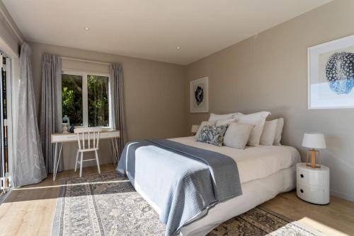 sypialnia z łóżkiem, biurkiem i oknem w obiekcie Tree-top luxury in the Waitakere Ranges w Auckland