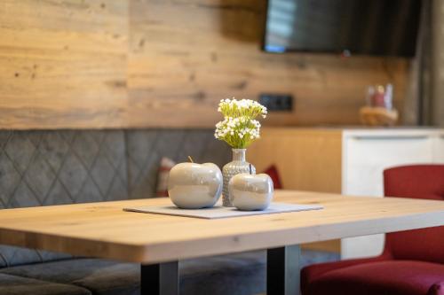 a wooden table with a vase with flowers in it at Sport Apart in Zell am Ziller