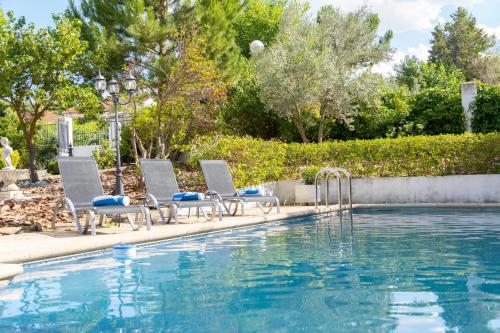 einen Pool mit 2 Stühlen und einem Brunnen in der Unterkunft Casa Rural - Suerte (+Piscina) in Illana