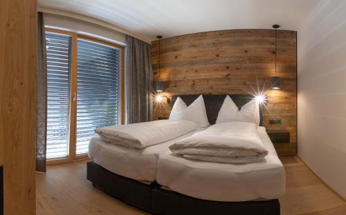 una camera da letto con un grande letto con cuscini bianchi di Sport Apart a Zell am Ziller