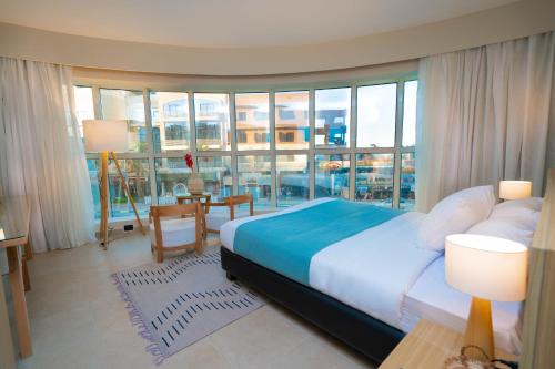 a bedroom with a bed and a large window at Redcon Suites in Hurghada