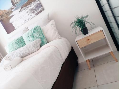 Un dormitorio con una cama y una mesa con una planta. en The Blyde Riverwalk Estate en Pretoria