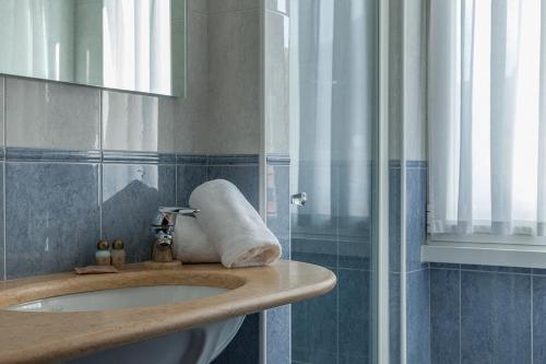 a bathroom with a sink and a mirror at Hotel Benaco Garda ***S in Garda