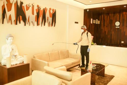 a man wearing a mask standing in a living room at Hotel German Palace Near to Airport in Gandhinagar