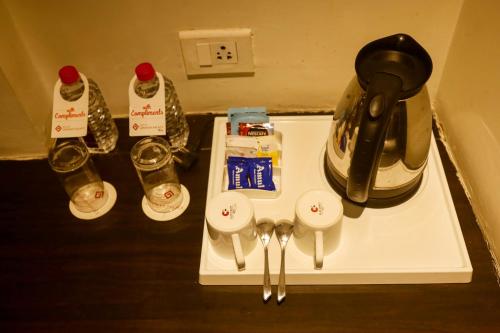 a table with a coffeemaker and a coffee maker at Hotel German Palace Near to Airport in Gandhinagar