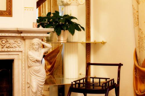 a statue of a woman sitting on a table next to a chair at Pearl Mini-Hotel in Odesa