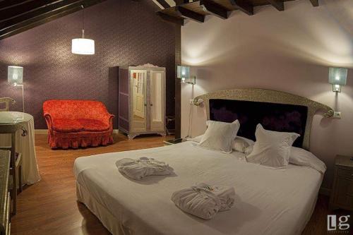 a bedroom with a large bed with towels on it at Posada torre del milano in Comillas