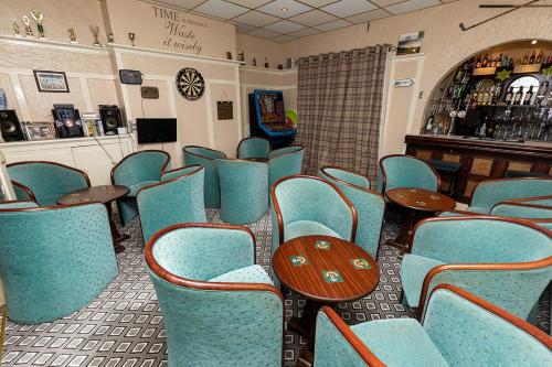 a restaurant with blue chairs and tables and a bar at California Guest House in Blackpool