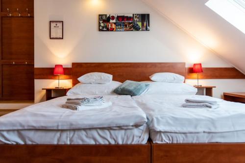 two twin beds in a room with two lamps at Fényes Vinorium in Sopron