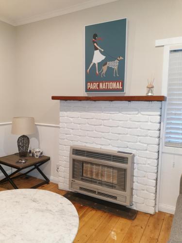 a white brick fireplace with a picture of a woman riding a horse at Miner's Retreat in Miners Rest