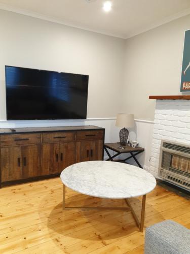 a living room with a tv and a coffee table at Miner's Retreat in Miners Rest