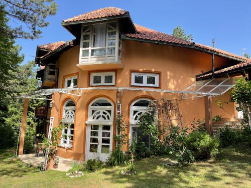 an orange house with white doors and windows at Apartments Micic in Zlatibor