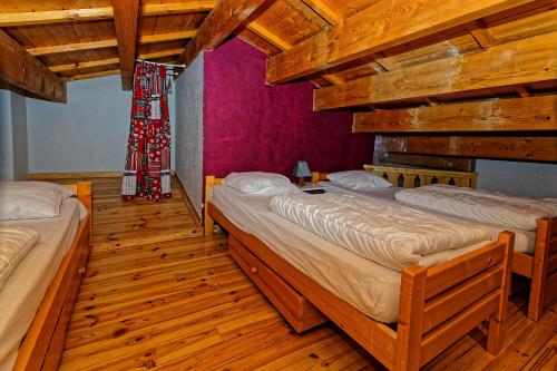 twee bedden in een kamer met houten vloeren bij le burel 5 personnes in Lanslevillard