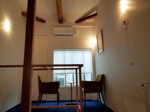 京都的住宿－koume no tonari コウメノトナリ，一间设有两把椅子、一张桌子和一个窗户的房间