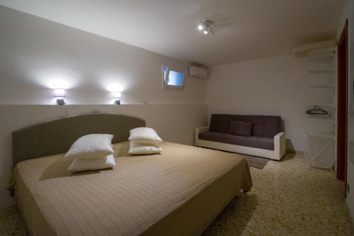 a bedroom with a bed and a couch at Borgo Canneto in Rodi Garganico