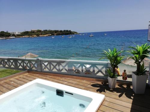 a bath tub on a deck with a view of the ocean at LENICO Seafront Villa in Agia Pelagia