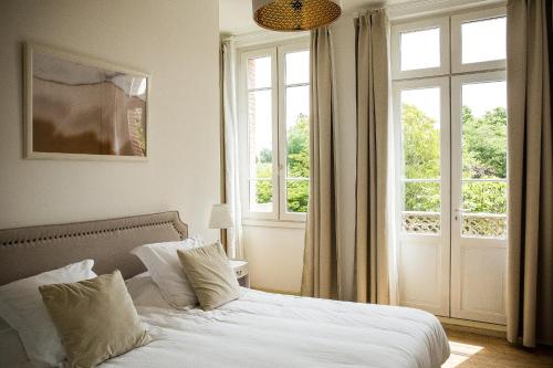 1 dormitorio con cama blanca y ventana en Au Coeur des Eléments, en Saint-Nicolas-de-la-Grave