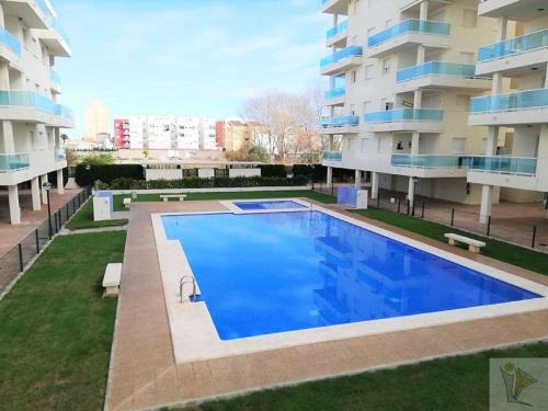 a large swimming pool in front of a building at Apartamento en Piles Playa in Piles