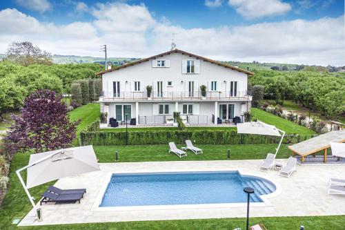 una gran casa blanca con piscina frente a ella en Suite junior en Capranica