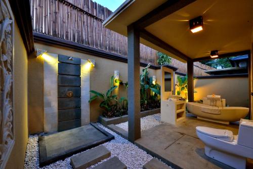 an outdoor bathroom with a toilet and a sink at Gino Feruci Villa Ubud by KAGUM Hotels in Ubud