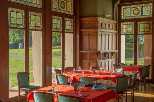 a dining room with red tables and chairs and windows at VTF Le Domaine de Françon in Biarritz