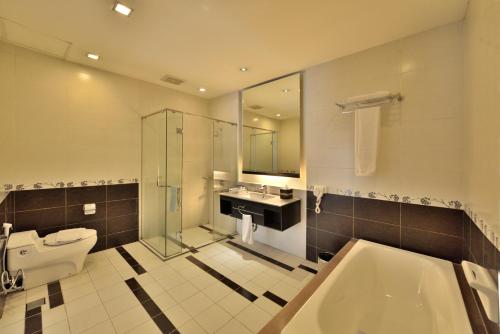 a bathroom with a toilet and a sink and a tub at Golden Flower by KAGUM Hotels in Bandung