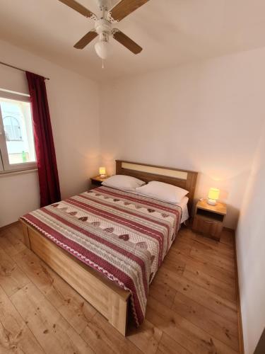 ein Schlafzimmer mit einem Bett mit zwei Lampen an zwei Tischen in der Unterkunft Guesthouse Marko in Povljana
