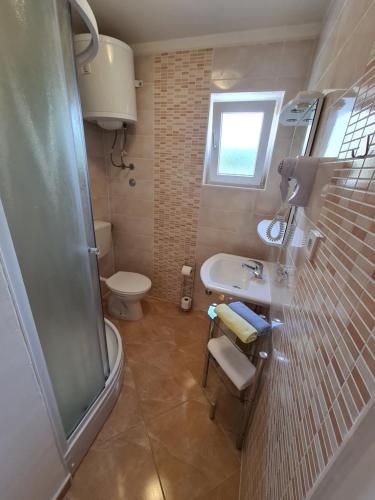 a bathroom with a toilet and a sink and a shower at Guesthouse Marko in Povljana