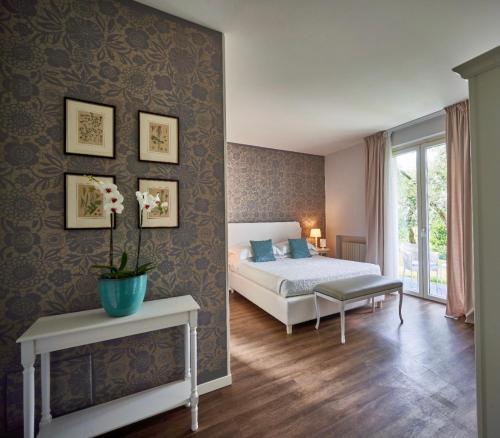 a bedroom with a bed and a table with a vase on it at Hotel Clodia - Adults Only in Sirmione