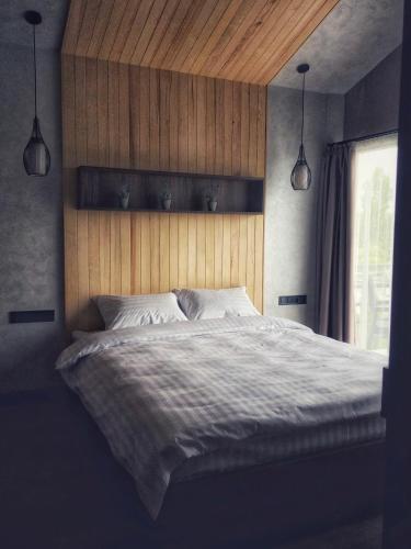 a bedroom with a large bed with a wooden headboard at WindRose in Zatoka