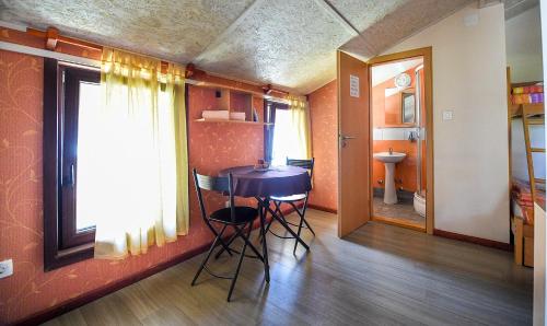a room with a table and chairs and a bathroom at San Art Floating Hostel & Apartments in Belgrade