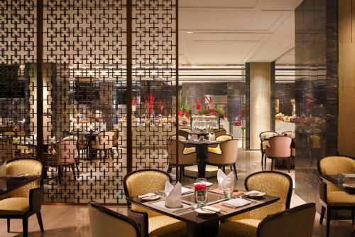 a restaurant with tables and chairs and a large window at Crowne Plaza Beijing Lido by IHG in Beijing