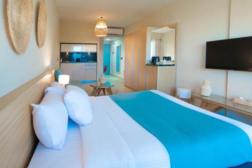 a bedroom with a blue and white bed and a tv at Redcon Suites in Hurghada