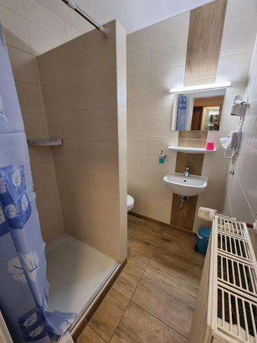 a bathroom with a shower and a sink at Hotel Pension Nordseewelle in Norddeich