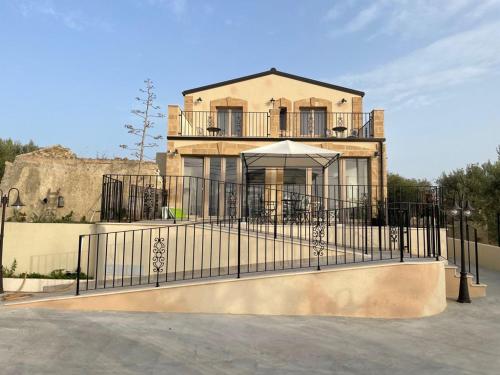 un bâtiment avec une porte en face d'une maison dans l'établissement Bàcula Nzícula Marzamemi, à Marzamemi