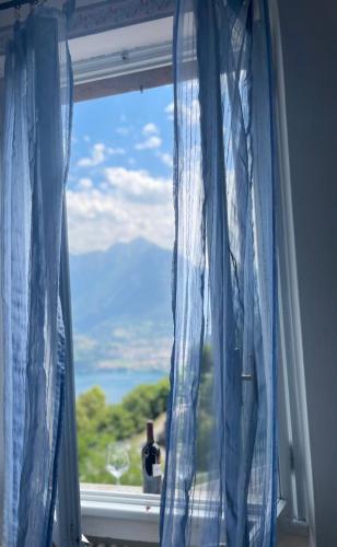 a window with blue curtains in a room at Hotel Mirabeau in Bellagio