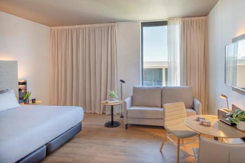 a hotel room with a bed and a couch and a chair at INNSiDE by Meliá Luxembourg in Luxembourg