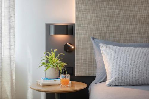 a bed with a table with a glass of orange juice on it at INNSiDE by Meliá Luxembourg in Luxembourg