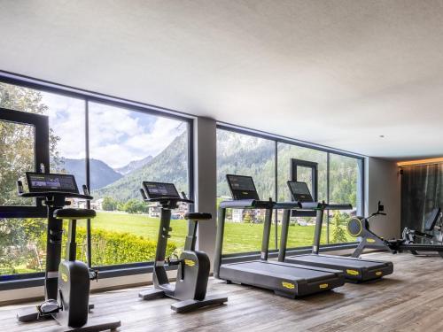 a gym with a large window and cardio machines at Hotel Auszeit in Pertisau