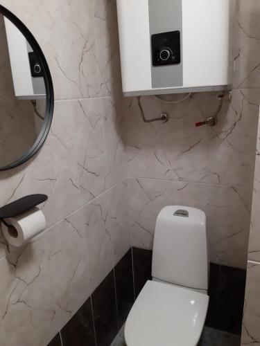a bathroom with a white toilet and a mirror at Apartement in Kipi