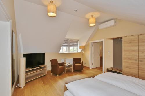 a bedroom with a bed and a table with chairs at Hotel Theophano in Quedlinburg