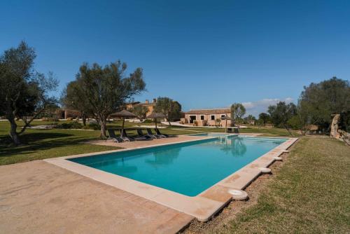 una piscina en un patio con una casa al fondo en Agroturismo Sa Canoveta, en Colonia de Sant Jordi