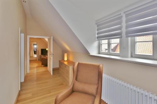 a living room with a chair and a window at Hotel Theophano in Quedlinburg