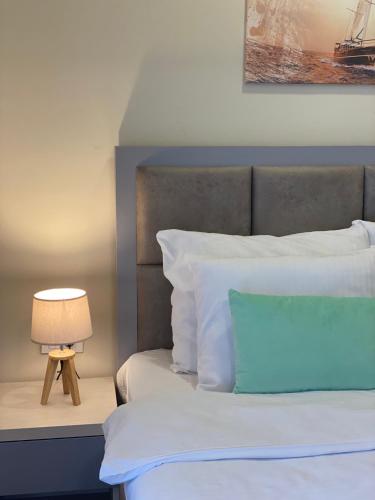 a bedroom with a bed and a lamp on a table at Hotel Olimpija plus in Herceg-Novi
