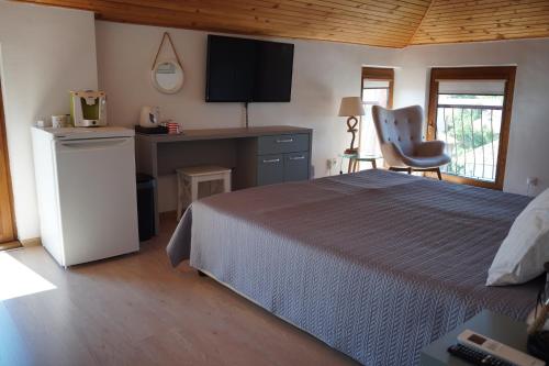 a bedroom with a bed and a desk and a chair at Guest House Lambovi in Nesebar