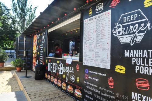 a food truck with a menu on the side of it at Élmény Balaton Hotel in Alsóörs