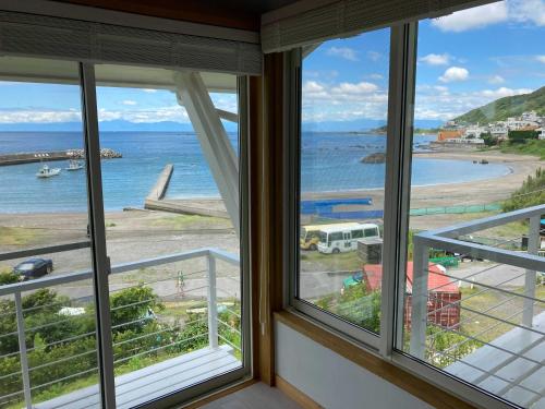 a view of the ocean from a room with windows at GLOCE 葉山 Ocean View House 都心から1時間 湘南の絶景を独り占めペットok 出張BBQ有り in Yokosuka