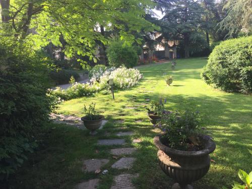a garden with potted plants on a lawn at Il Loft di Villa al Parco in Sala Baganza