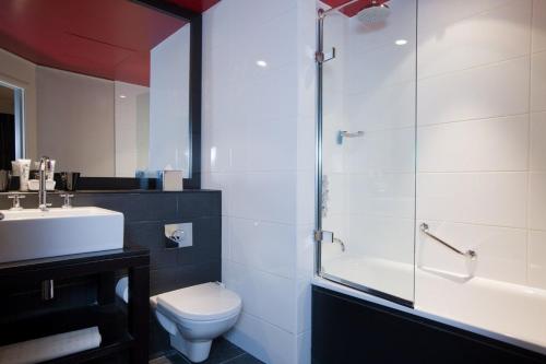 a bathroom with a toilet, sink, and shower at Malmaison Newcastle in Newcastle upon Tyne